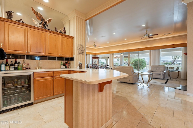 kitchen with beverage cooler, a breakfast bar, decorative backsplash, light countertops, and open floor plan