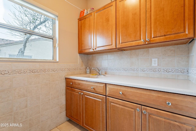 kitchen with light countertops, brown cabinets, and a sink