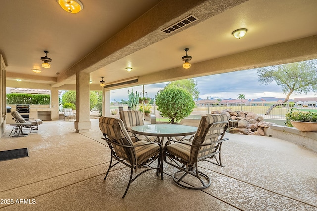 view of patio / terrace with outdoor dining area, fence, and visible vents