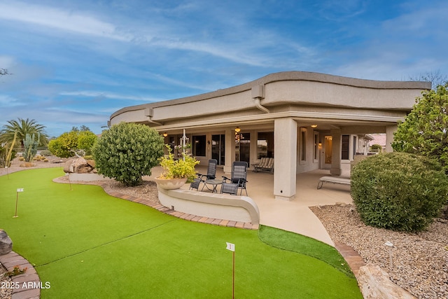 back of property featuring a patio and stucco siding