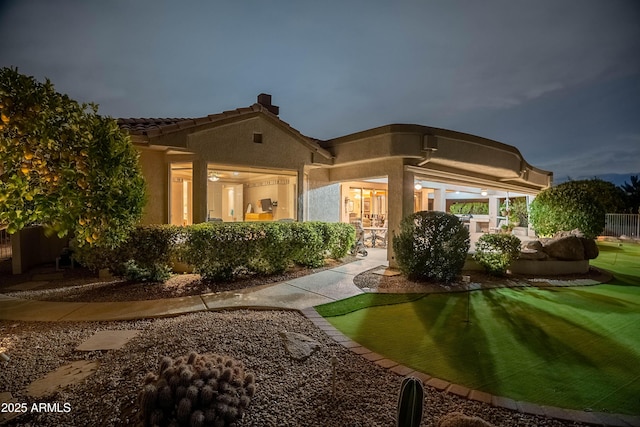 exterior space featuring stucco siding, a patio, and a tiled roof