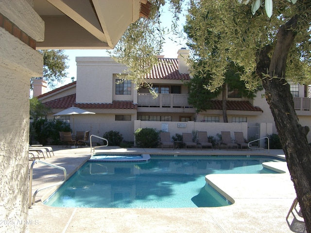 view of swimming pool with a community hot tub and a patio area