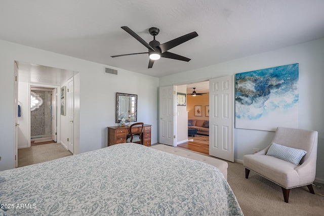 carpeted bedroom featuring ensuite bath and ceiling fan