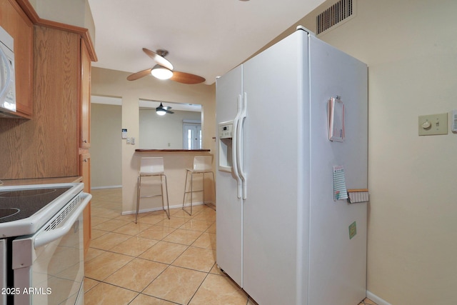 kitchen with ceiling fan, white appliances, and light tile patterned floors