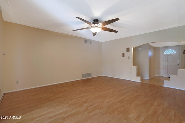 empty room with ceiling fan, ornamental molding, and light wood-type flooring