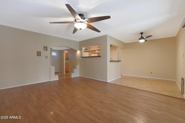 unfurnished living room with ceiling fan, crown molding, and light hardwood / wood-style flooring