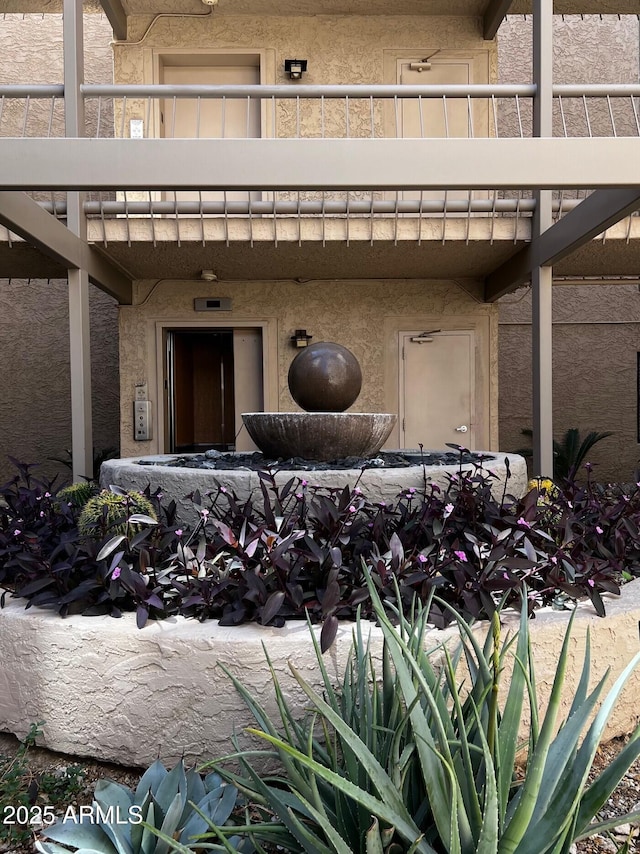 entrance to property with stucco siding and a balcony