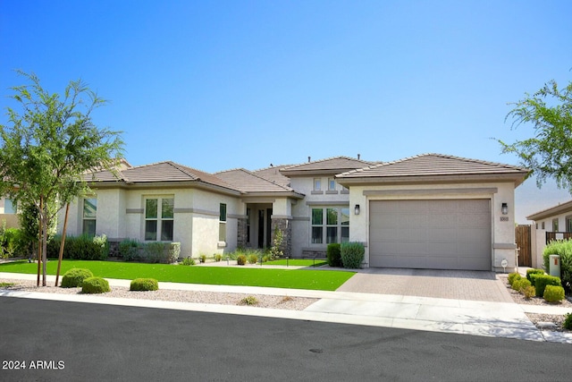 prairie-style house featuring a garage and a front lawn