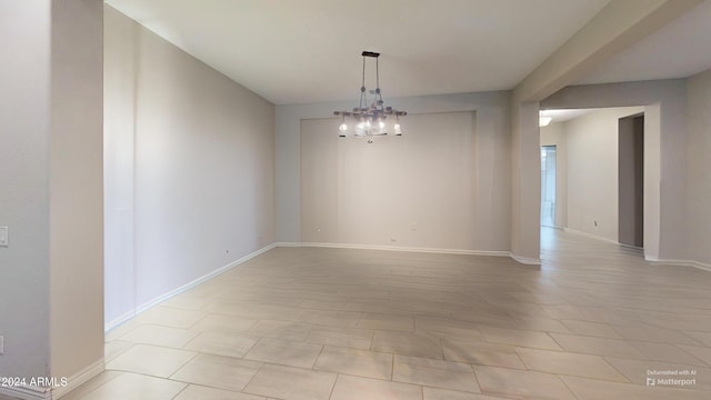 spare room with an inviting chandelier