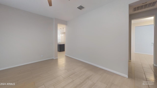 empty room featuring ceiling fan and light wood-type flooring