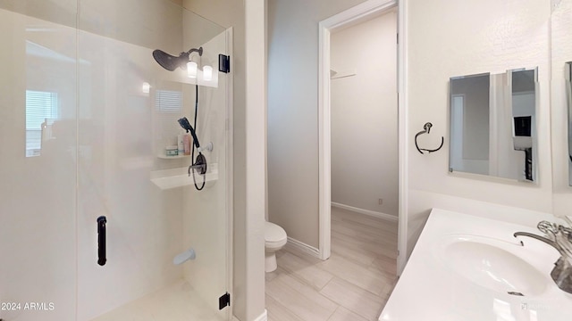 bathroom with vanity, a shower with door, and toilet