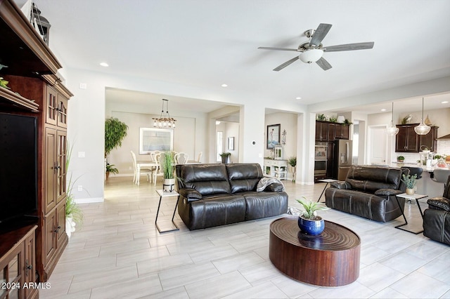 living room with ceiling fan with notable chandelier