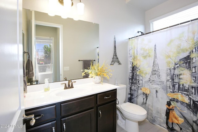 bathroom with vanity, a shower with shower curtain, and toilet