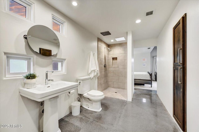 full bath featuring toilet, visible vents, and tiled shower