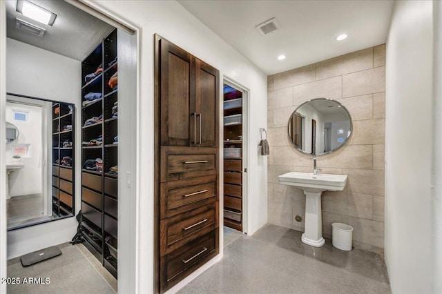 full bath with visible vents, tile walls, and a spacious closet