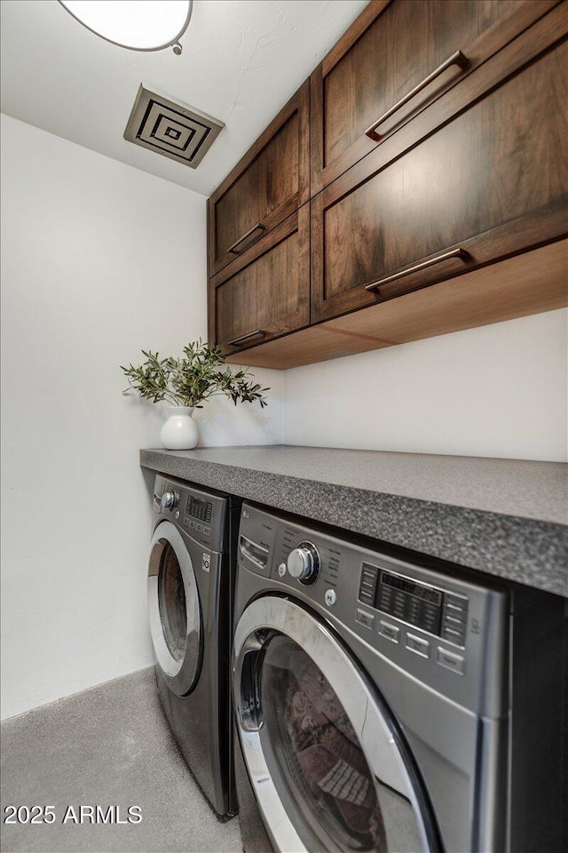 laundry room featuring washing machine and dryer and cabinet space