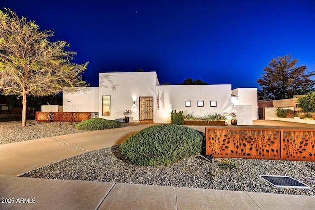 pueblo-style house featuring stucco siding