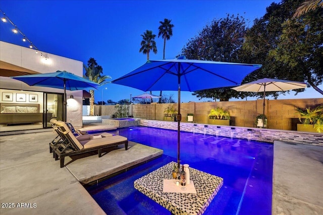 view of pool featuring a patio, a pool with connected hot tub, and a fenced backyard