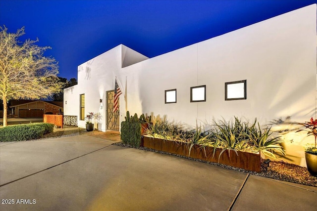 view of side of home with a patio area and stucco siding