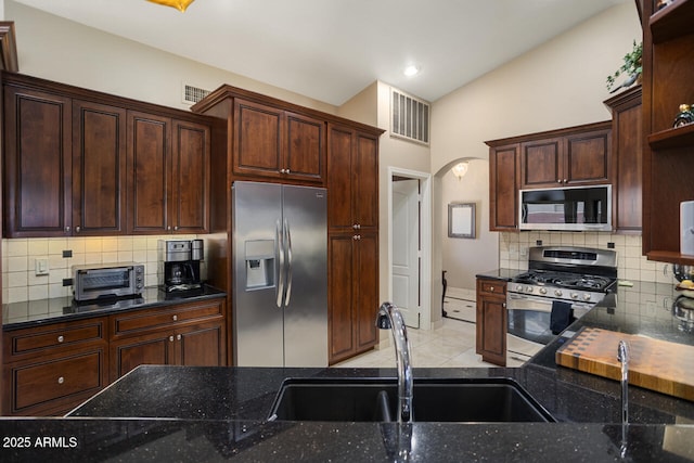 3394 N 147th Ln, Goodyear, AZ 85395 - kitchen featuring stainless steel appliances, a sink, backsplash, dark stone counters, and recessed lighting