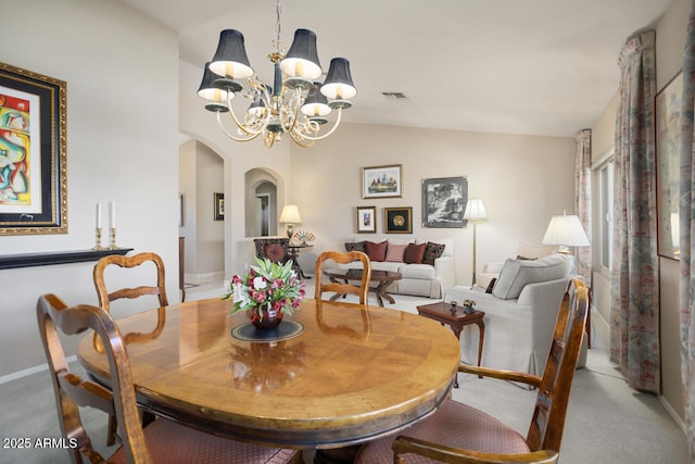 3394 N 147th Ln, Goodyear, AZ 85395 - dining area featuring arched walkways, a chandelier, lofted ceiling, and carpet flooring