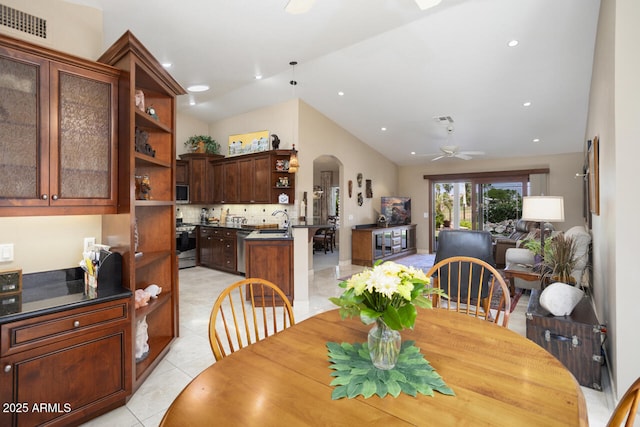 3394 N 147th Ln, Goodyear, AZ 85395 - dining room with a ceiling fan, arched walkways, vaulted ceiling, light tile patterned flooring, and recessed lighting