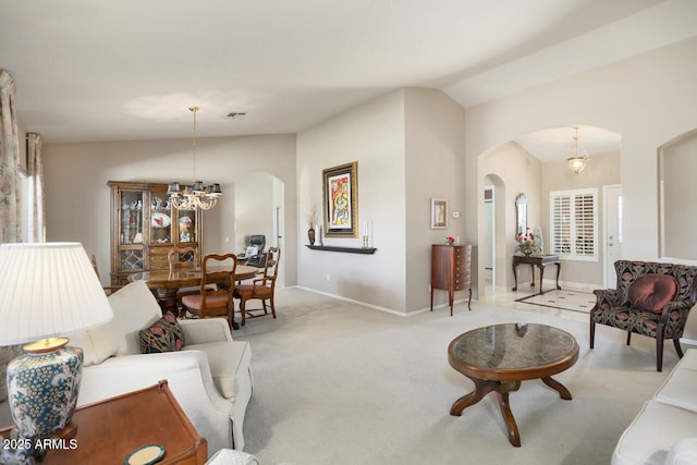 3394 N 147th Ln, Goodyear, AZ 85395 - living room featuring arched walkways, vaulted ceiling, light colored carpet, a chandelier, and baseboards
