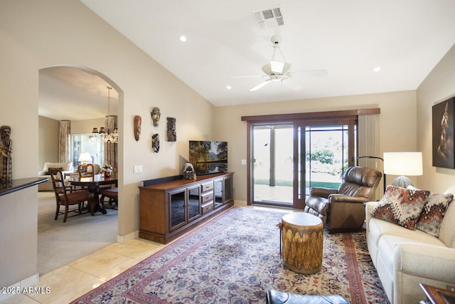 3394 N 147th Ln, Goodyear, AZ 85395 - living room with arched walkways, ceiling fan, light carpet, vaulted ceiling, and light tile patterned flooring