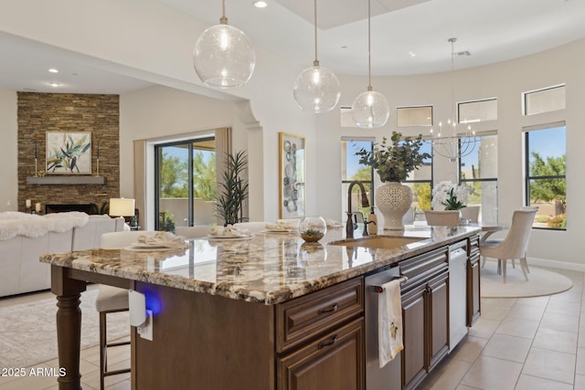 6450 E Monterra Way, Scottsdale, AZ 85266 - kitchen with open floor plan, light tile patterned floors, light stone countertops, recessed lighting, and a stone fireplace