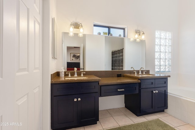 bathroom with a sink, tile patterned floors, double vanity, and tiled bath