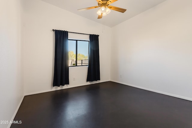 spare room featuring concrete flooring, baseboards, a ceiling fan, and vaulted ceiling