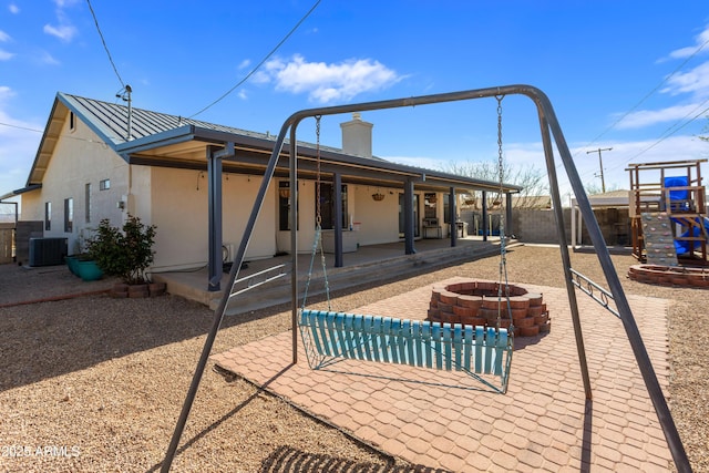 back of property with an outdoor fire pit, a patio area, stucco siding, and fence