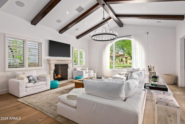 living area with vaulted ceiling with beams, light wood-style flooring, a premium fireplace, and visible vents