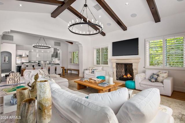 living area with a lit fireplace, beamed ceiling, and visible vents