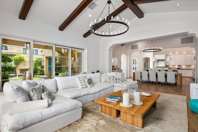 living room with arched walkways, high vaulted ceiling, and visible vents