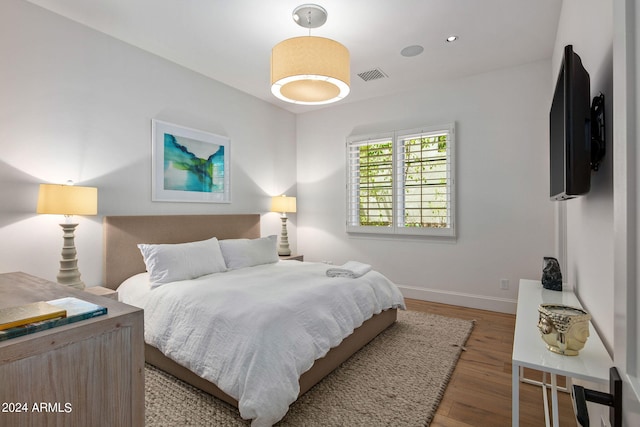 bedroom with baseboards, visible vents, wood finished floors, and recessed lighting