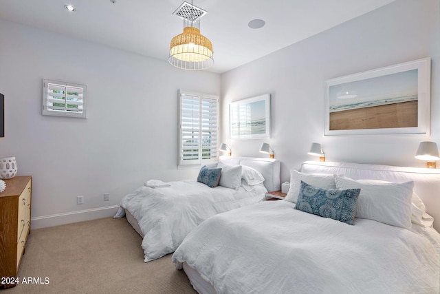 bedroom featuring light carpet and baseboards