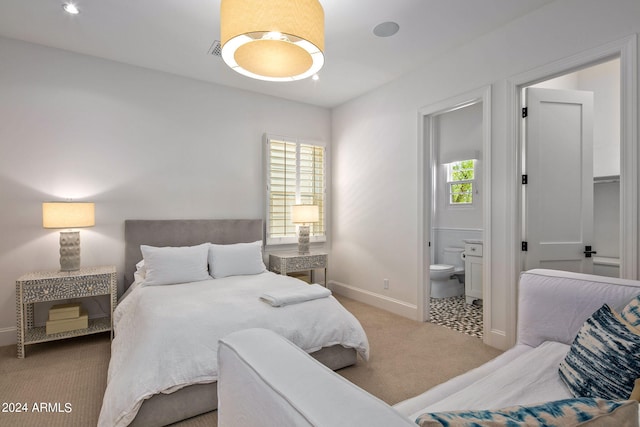 bedroom with carpet, baseboards, and ensuite bathroom