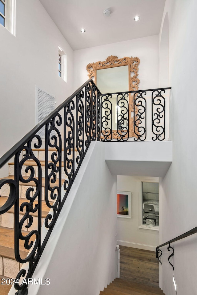 stairway with recessed lighting, baseboards, and wood finished floors