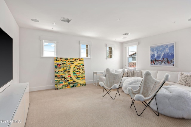 sitting room with light carpet, visible vents, and baseboards