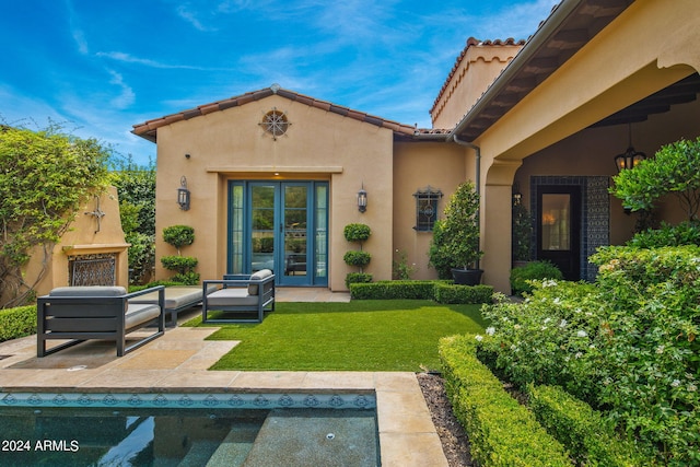 back of house with a patio area, a lawn, outdoor lounge area, and stucco siding