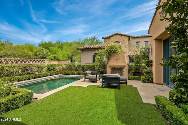 view of pool featuring a warm lit fireplace, a patio area, fence, and a fenced in pool