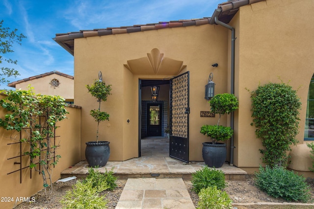 doorway to property with a tile roof and stucco siding