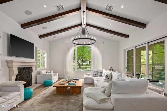 living area featuring visible vents, a notable chandelier, lofted ceiling with beams, and a fireplace