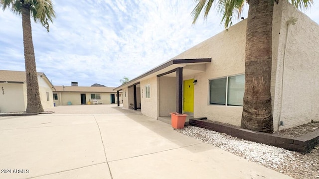 view of home's exterior featuring concrete driveway and stucco siding