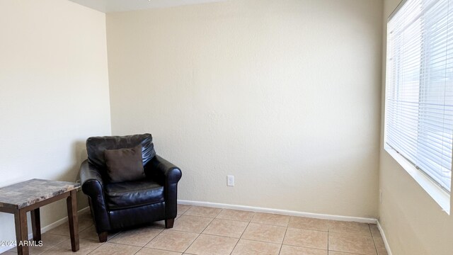 sitting room with light tile patterned floors, a wealth of natural light, and baseboards