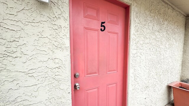 doorway to property featuring stucco siding