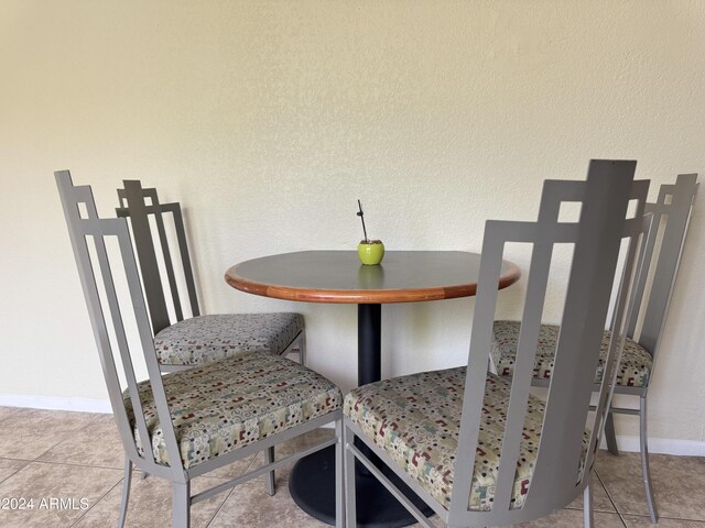 tiled dining room featuring baseboards