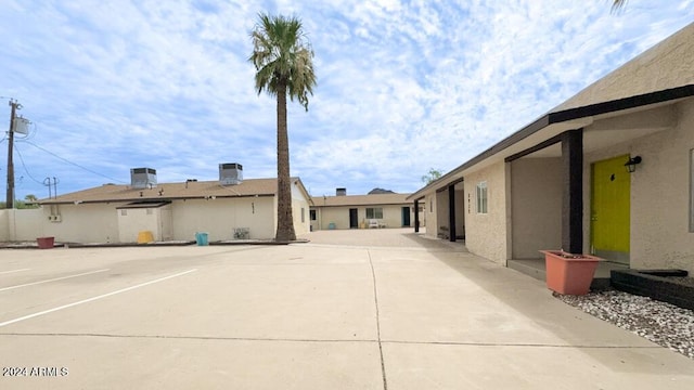 view of home's exterior featuring uncovered parking, central AC, and stucco siding