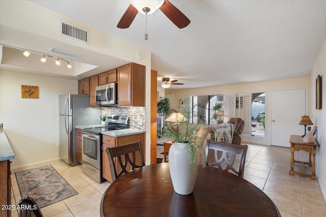 16510 E Palisades Blvd Unit 42, Fountain Hills, AZ 85268 - dining space with ceiling fan, light tile patterned floors, a textured ceiling, track lighting, and baseboards